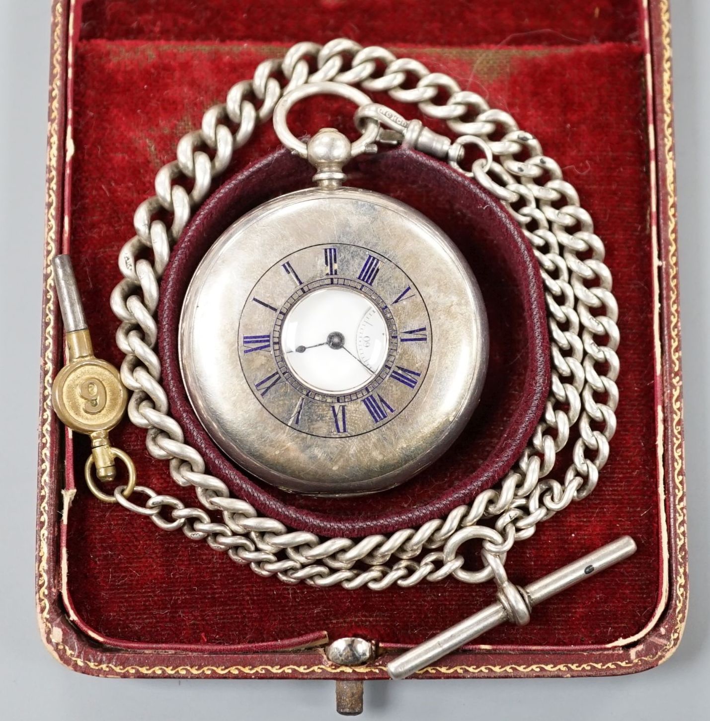 A 925 half hunter keywind pocket watch, cased diameter 46mm, on a silver albert with watch key.